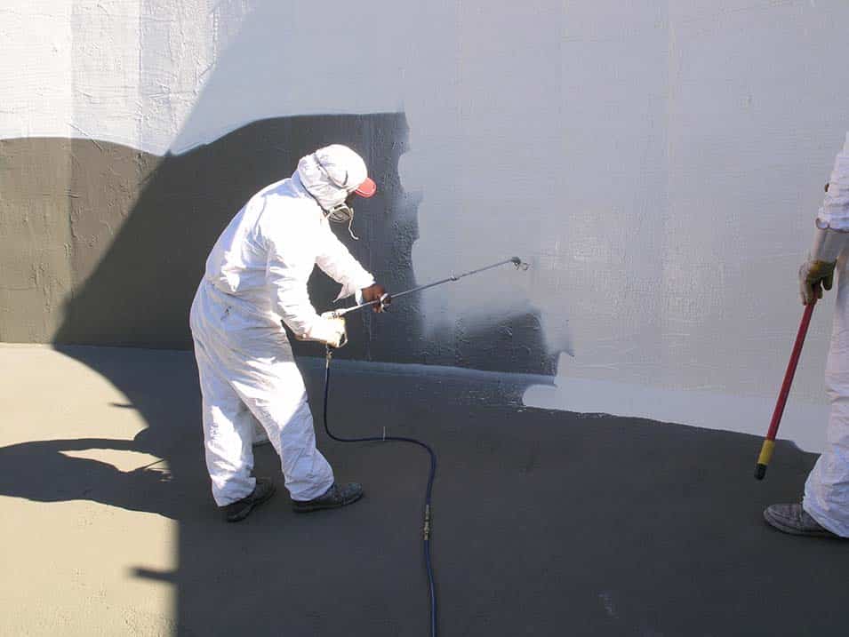 A worker repaints the inside of a tank.