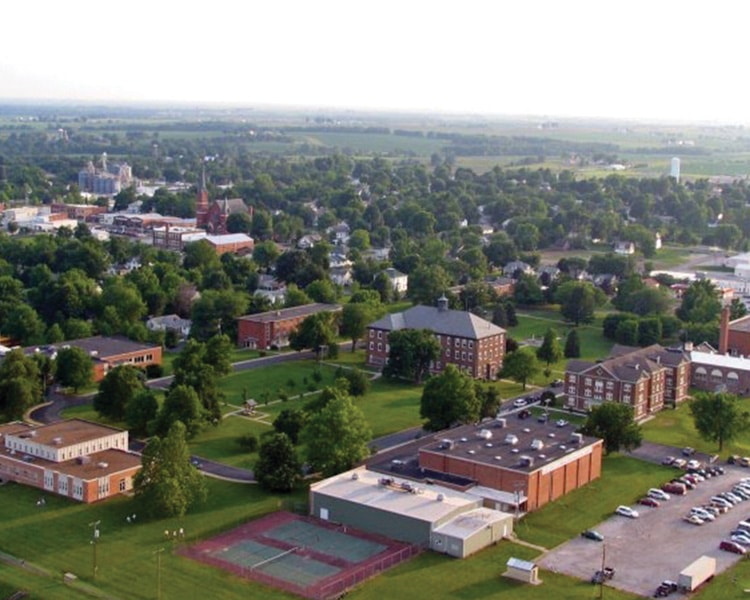 An aerial view of a campus with tennis courts.