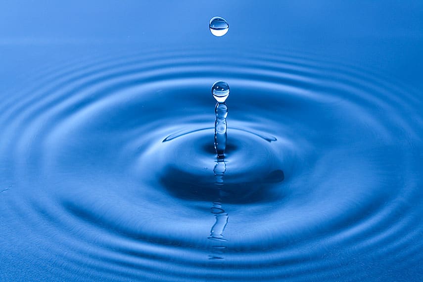 A drop of water ripples as it hits the surface.