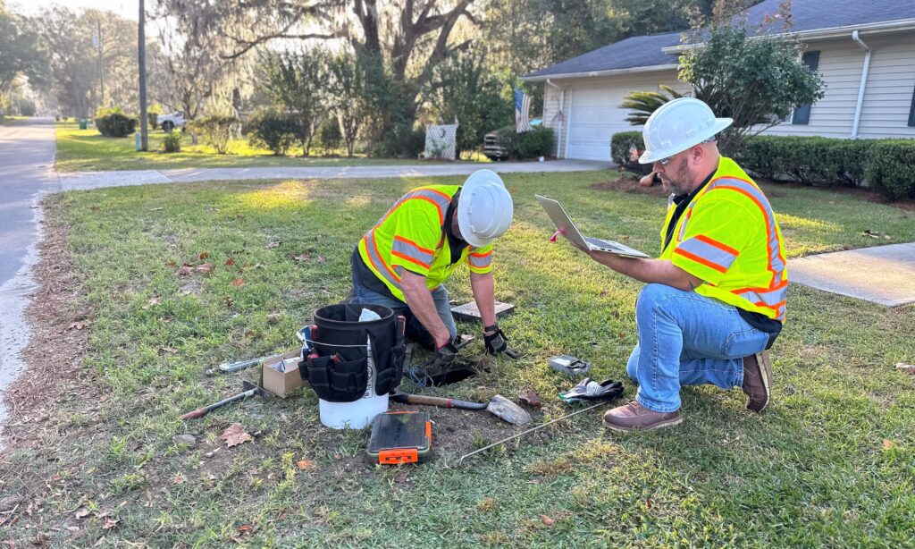 Two USG Water field consultants working on a water meter in the front yard